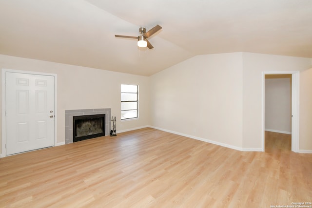 unfurnished living room with light hardwood / wood-style floors, ceiling fan, a fireplace, and vaulted ceiling