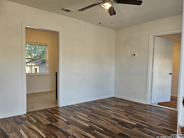 spare room with dark hardwood / wood-style floors and ceiling fan