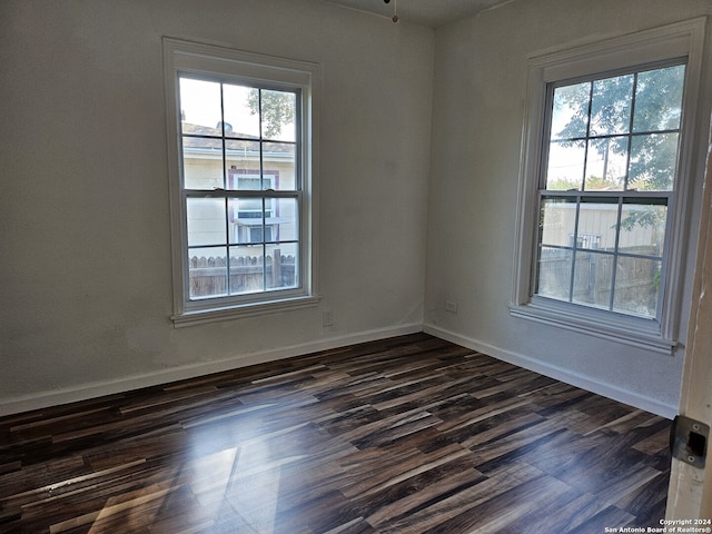 empty room with dark wood finished floors, ceiling fan, and baseboards