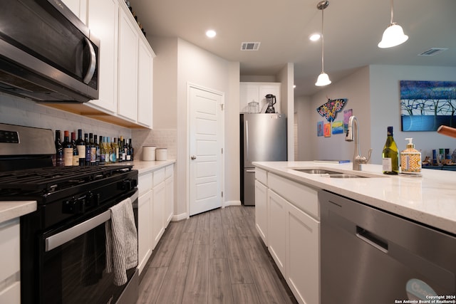 kitchen featuring stainless steel appliances, hardwood / wood-style floors, and white cabinets