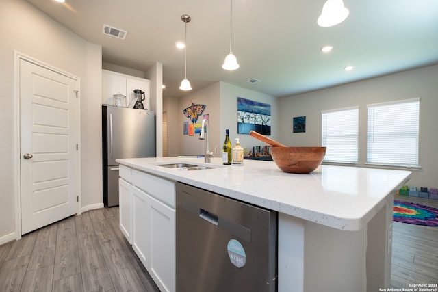 kitchen featuring an island with sink, appliances with stainless steel finishes, white cabinetry, pendant lighting, and sink