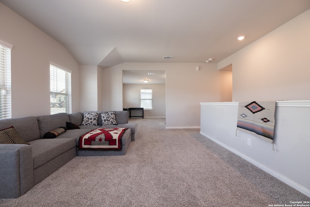 carpeted living room with vaulted ceiling