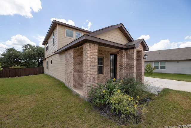 view of side of home with a patio area and a lawn