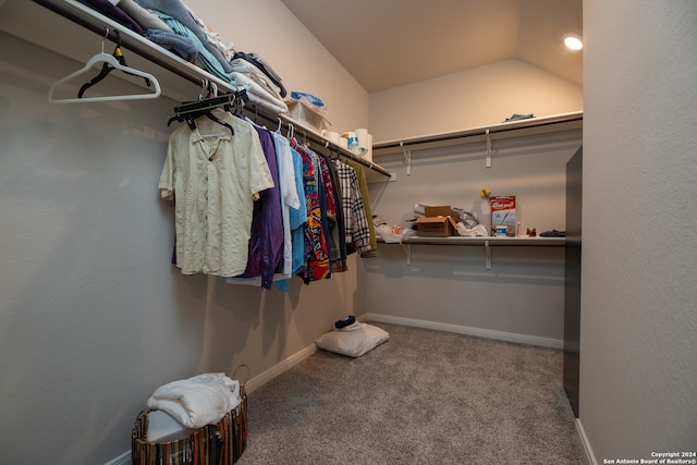 walk in closet with carpet and vaulted ceiling