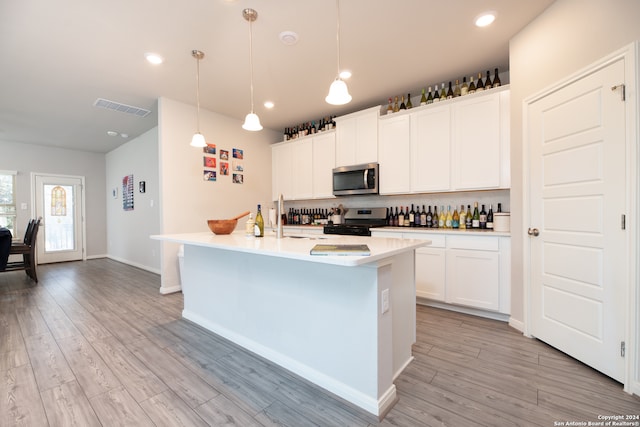 kitchen featuring white cabinets, a kitchen island with sink, and stainless steel appliances