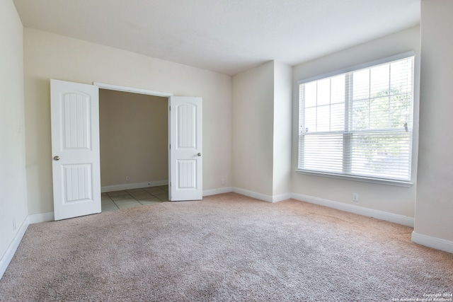 unfurnished room featuring light colored carpet