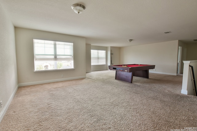 game room with a textured ceiling, light colored carpet, and billiards