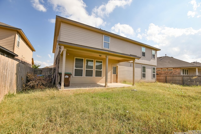 rear view of property featuring a patio area and a lawn