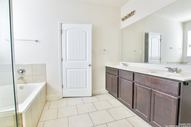 bathroom featuring vanity, a relaxing tiled tub, and tile patterned floors