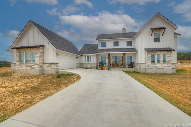 modern inspired farmhouse featuring a front lawn and a garage