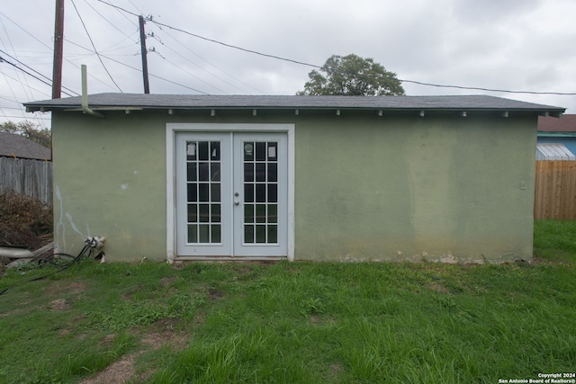 view of property exterior with french doors and a lawn