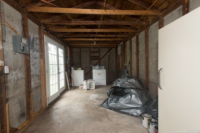 miscellaneous room featuring washer and dryer, electric panel, lofted ceiling, and concrete flooring