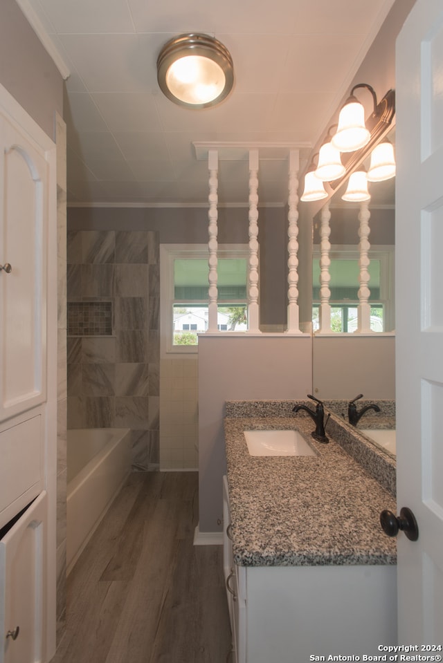 bathroom with vanity, crown molding, plus walk in shower, and wood-type flooring