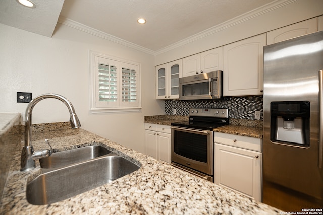 kitchen with white cabinets, tasteful backsplash, dark stone countertops, sink, and stainless steel appliances