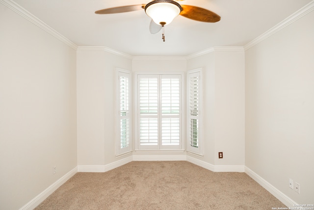 carpeted spare room with crown molding and ceiling fan