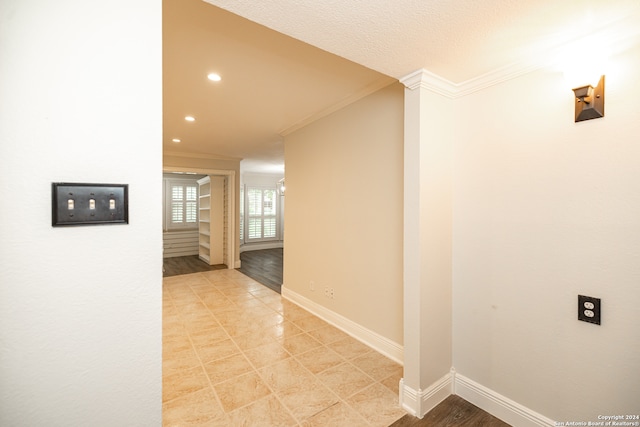 hall with ornamental molding and light wood-type flooring