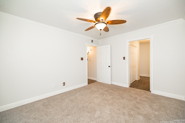 carpeted spare room with crown molding and ceiling fan