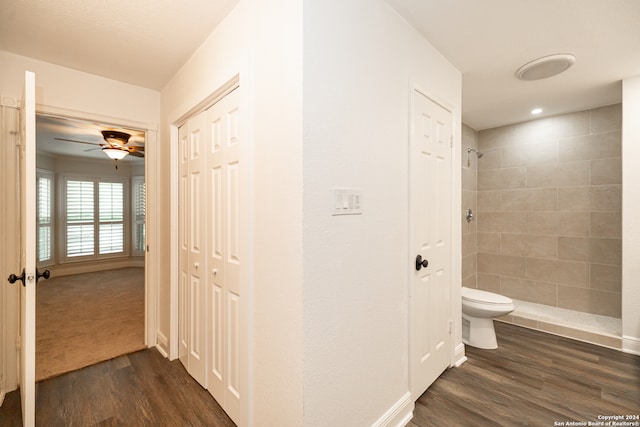 bathroom featuring toilet, hardwood / wood-style floors, ceiling fan, and tiled shower