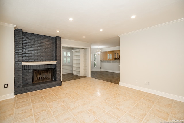 unfurnished living room featuring crown molding, light hardwood / wood-style floors, a fireplace, and built in features