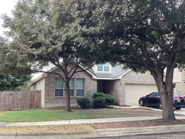 view of front of property featuring a garage, concrete driveway, brick siding, and fence