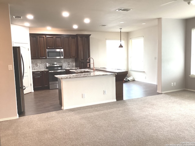 kitchen with dark colored carpet, appliances with stainless steel finishes, a sink, and visible vents