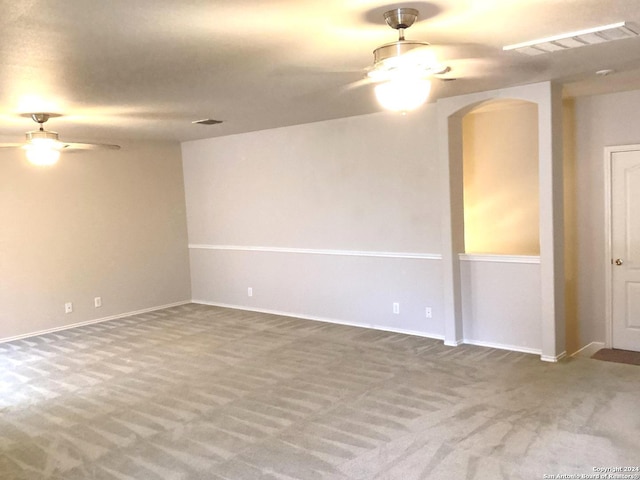 spare room featuring carpet floors, visible vents, and a ceiling fan