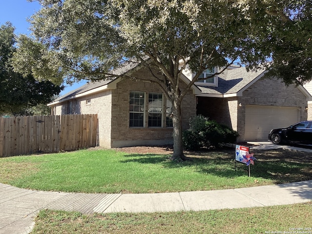 view of front of house with brick siding, roof with shingles, an attached garage, fence, and a front lawn