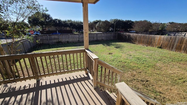 deck with a fenced backyard and a lawn