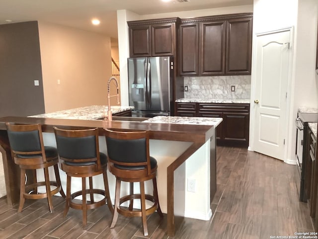 kitchen featuring dark wood-style floors, backsplash, dark brown cabinetry, and stainless steel refrigerator with ice dispenser