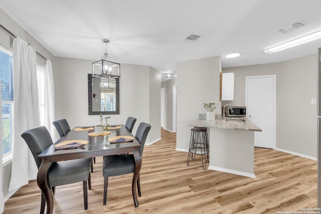8722 Ridge Moon Dr, San Antonio, TX 78239 - dining area with light wood-style floors and baseboards