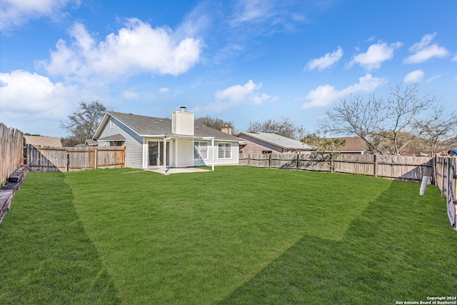 rear view of house with a patio area and a lawn