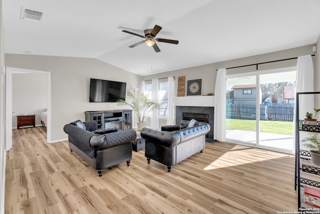 8722 Ridge Moon Dr, San Antonio, TX 78239 - living room featuring a tile fireplace, lofted ceiling, ceiling fan, light wood-style flooring, and baseboards