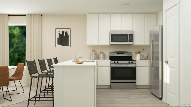 kitchen with stainless steel appliances, sink, a breakfast bar, light wood-type flooring, and white cabinets