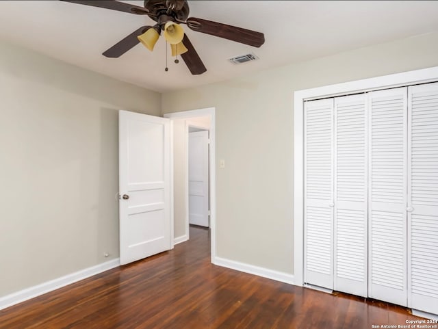 unfurnished bedroom with a closet, dark hardwood / wood-style floors, and ceiling fan