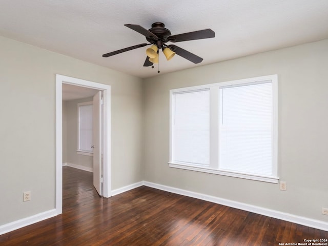 spare room featuring dark wood-type flooring, ceiling fan, and a textured ceiling