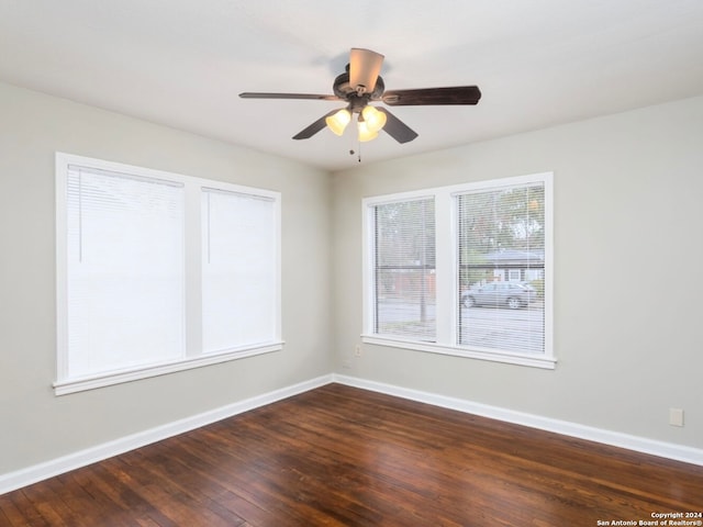 empty room with dark wood-type flooring and ceiling fan