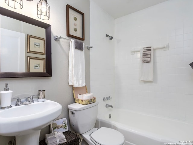 full bathroom featuring toilet, tiled shower / bath, and sink