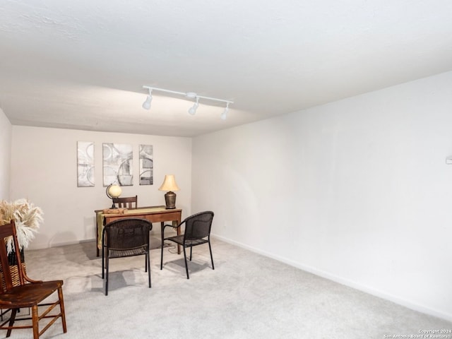 carpeted office featuring track lighting