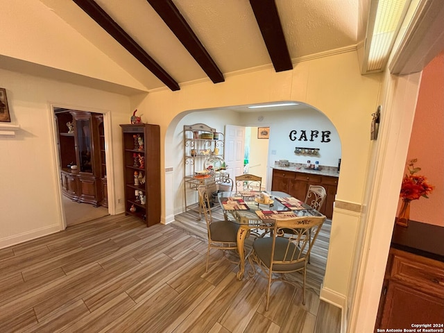 dining space with lofted ceiling with beams