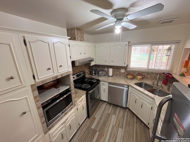 kitchen featuring appliances with stainless steel finishes, white cabinets, sink, and ventilation hood