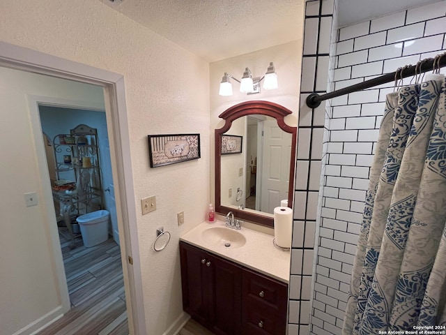 bathroom with vanity, hardwood / wood-style flooring, a textured ceiling, and a shower with shower curtain