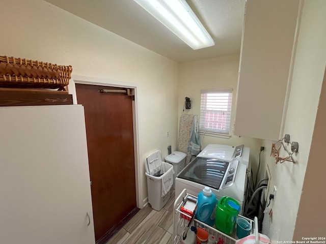 clothes washing area featuring washer and dryer and light wood-type flooring