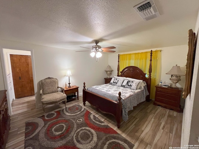 bedroom featuring a textured ceiling, hardwood / wood-style flooring, and ceiling fan