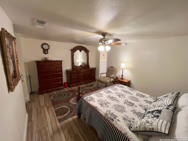 bedroom featuring ceiling fan, a textured ceiling, and hardwood / wood-style floors