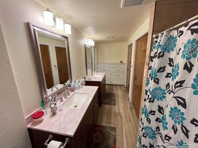 bathroom featuring vanity, hardwood / wood-style flooring, and a textured ceiling