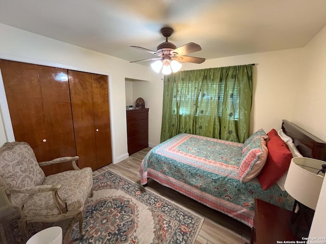 bedroom featuring light hardwood / wood-style floors, a closet, and ceiling fan