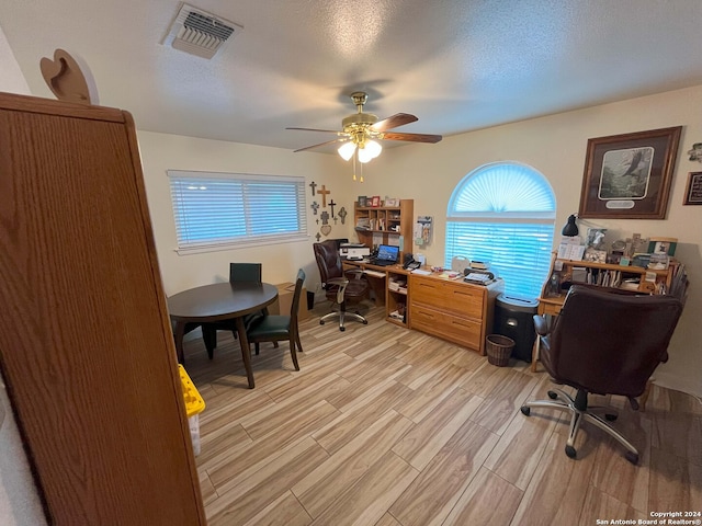 office area with light hardwood / wood-style flooring, a textured ceiling, and ceiling fan