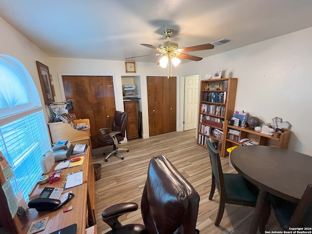 home office featuring ceiling fan and light hardwood / wood-style flooring