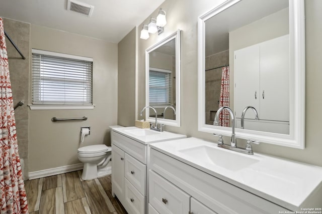 full bathroom featuring visible vents, a shower with shower curtain, toilet, wood finished floors, and vanity
