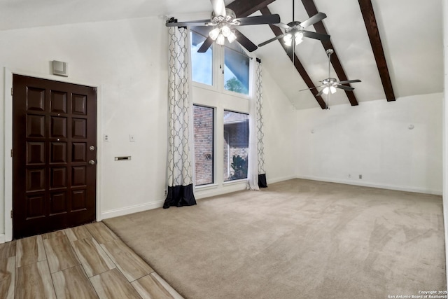 unfurnished living room featuring beam ceiling, high vaulted ceiling, ceiling fan, and baseboards